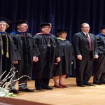 Faculty line up on stage and wait to be honored